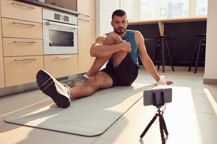 Man stretching to a video on his phone